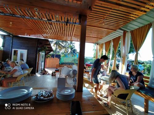 un gruppo di persone seduti a un tavolo in un ristorante di Bliss Water Resort ad Arambol