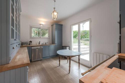 une cuisine avec une table au milieu dans l'établissement Standing cottage in Disneyland, à Chalifert