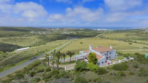 an aerial view of a large white house with a road at Fly Me To The Moon Guesthouse in Mossel Bay
