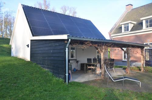a house with solar panels on the roof at UNIEK Bommelgaard, guesthouse in het prachtige Rivierenland! in Hurwenen