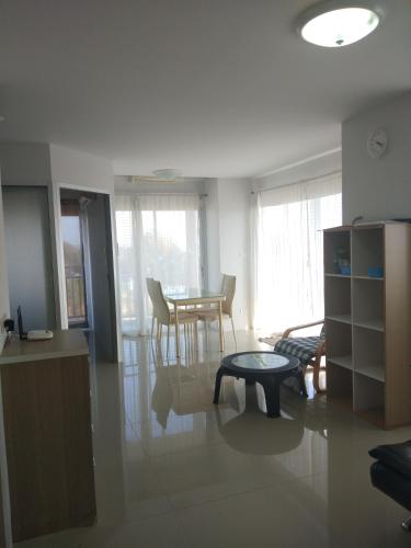 a living room with a table and a dining room at Grandbeach Condo Sea view by malai in Mae Pim