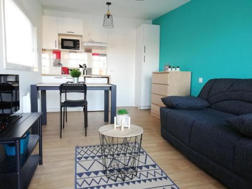 una sala de estar con un sofá y una mesa en Studios les 3 Eclats, en Saint-Laurent-sur-Sèvre