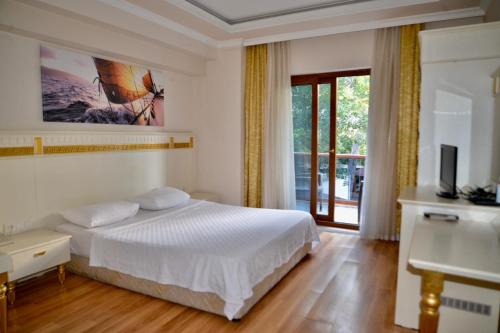 a bedroom with a white bed and a television at Barby Butik Otel in Kemer