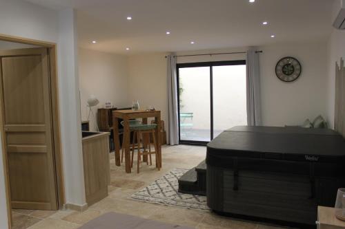 een woonkamer met een kamer met een tafel en een bureau bij Les secrets de l'isle in LʼIsle-sur-la-Sorgue
