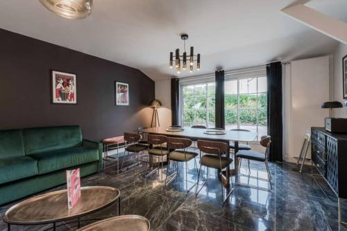 - un salon avec un canapé vert, une table et des chaises dans l'établissement Luxury brand new art déco Disneyland, à Chalifert