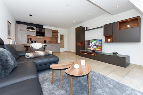ein Wohnzimmer mit einer Couch und einem Tisch in der Unterkunft Meerblick-Ferienwohnung Black Pearl in Bensersiel