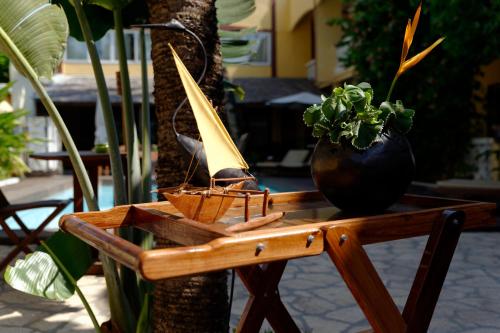 a wooden table with a potted plant on it at Hôtel Restaurant Coco Lodge Majunga in Mahajanga