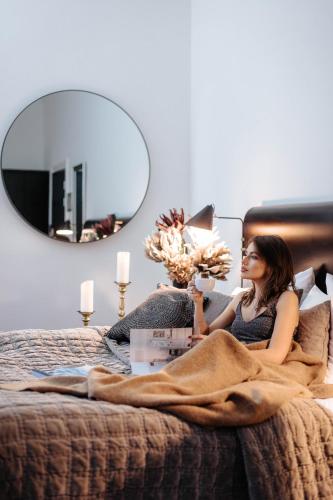 a woman laying on a bed with a mirror at Best Western Hotel Hebron in Copenhagen
