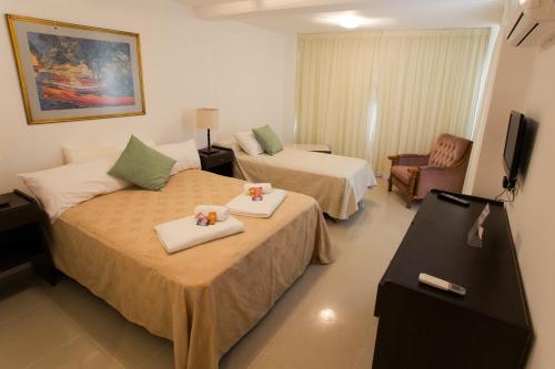 una habitación de hotel con dos camas y una silla en Hotel Lavalle, en General Lavalle