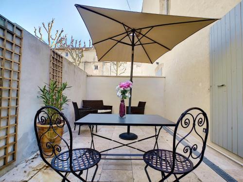 a table and chairs with an umbrella on a patio at Appartement avec terrasse en centre ville de Saint Remy de Provence in Saint-Rémy-de-Provence