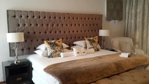 a bedroom with a large bed with a large headboard at Slaley Country House in Stellenbosch