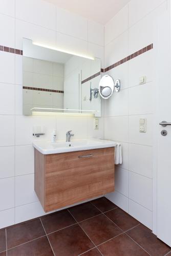 a bathroom with a sink and a mirror at Meerblick-Ferienwohnung Black Pearl in Bensersiel