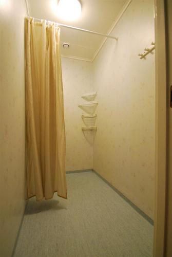 a room with a yellow curtain and shelves at Hellidens Slott in Tidaholm