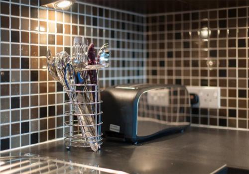 um balcão de cozinha com uma torradeira e algumas escovas de dentes em The Lochend Park View Residence em Edimburgo