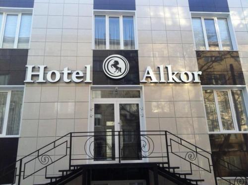 un hotel con un cartel en la parte delantera de un edificio en Alkor Hotel, en Volgograd