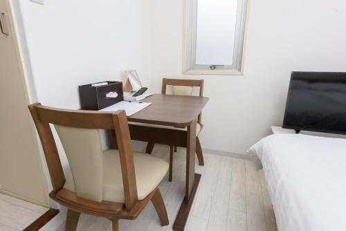 um pequeno quarto com uma secretária com uma cadeira e uma cama em COCOSTAY Global Noboricho4F ココステイ グローバル ノボリチョウ4F em Hiroshima