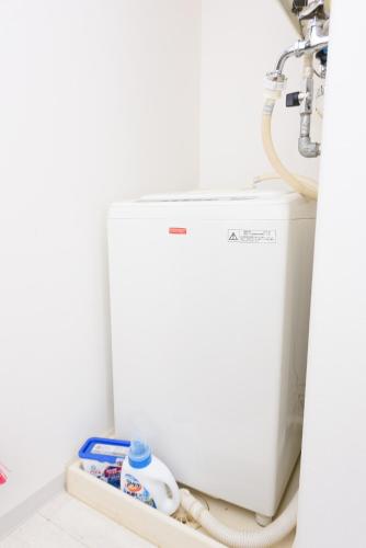 a white washing machine sitting in a bathroom at COCOSTAY Global Noboricho4F ココステイ グローバル ノボリチョウ4F in Hiroshima