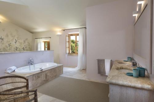 a large bathroom with a tub and a sink at Borgo Smeraldo Villas in Arzachena