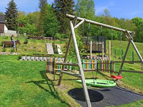 un parque infantil con columpio en un patio en Ferienwohnung Edelmann, en Markersbach