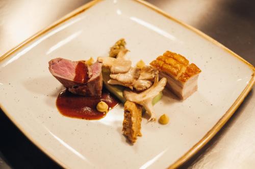 a white plate with food on a table at VILOTEL - Hotel & Restaurant in Oberkochen