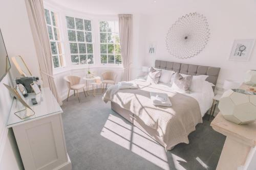 a white bedroom with a bed and a table at Old Bank Rooms in Bourton on the Water