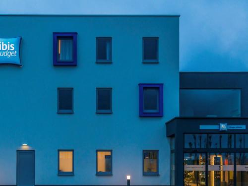 a blue building with a sign on the side of it at ibis budget Brugge Jabbeke in Jabbeke