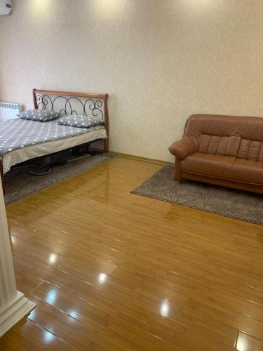 a living room with a bed and a couch at Apartment na Vladikavkazskoy in Vladikavkaz