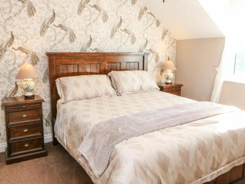 a bedroom with a large bed with two night stands at Anvil Cottage in Northallerton