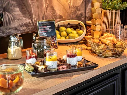a tray of food on a table with bread and fruit at Mercure La Roche Sur Yon in La Roche-sur-Yon