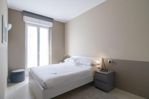 ein weißes Schlafzimmer mit einem Bett und einem Fenster in der Unterkunft Contempora Apartments - Cavallotti 13 - B62 in Mailand