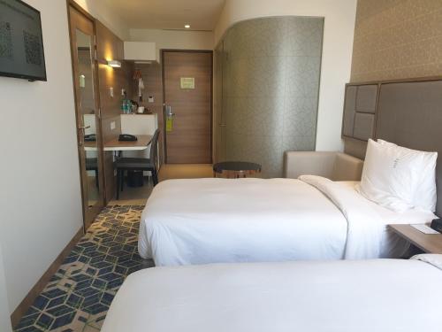 a hotel room with two beds and a desk at Holiday Inn Gurugram Sector 90 by IHG in Gurgaon