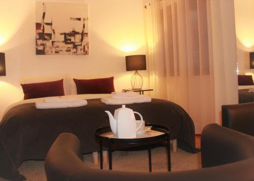 a hotel room with a bed with a table and chairs at Cosy Rooms in Sacavém