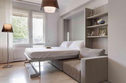 ein Bett und ein Sofa in einem Zimmer mit Fenster in der Unterkunft Contempora Apartments - Elvezia 8 - E23 in Mailand