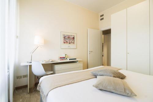 a white bedroom with a bed and a desk at Contempora Apartments - Elvezia 8 - E24 in Milan