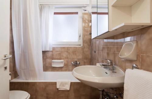 a bathroom with a sink and a toilet and a window at Contempora Apartments - Elvezia 8 - E24 in Milan