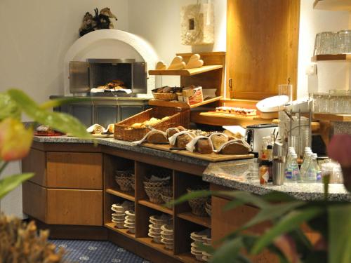 a kitchen with a counter with lots of bread at Hotel Garni Angela in Ischgl