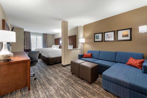 a hotel room with a couch and a bed at Comfort Suites in Dry Ridge