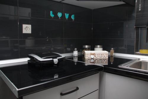 a kitchen with a black counter top and a sink at 3 Brothers III - sense of grey in Tríkala