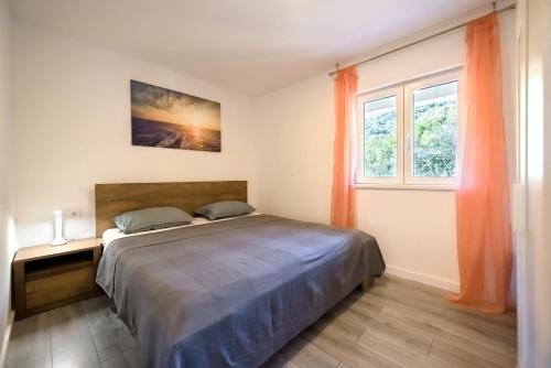 Schlafzimmer mit einem Bett und einem Fenster in der Unterkunft Feel Dugi otok apartments in Luka
