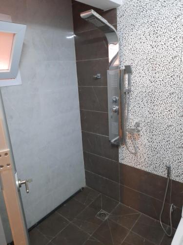 uma casa de banho com um chuveiro e uma porta de vidro em Haut standing Appartement F5 meublé à Dakar Ngor virage em Dakar