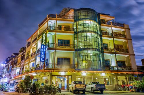 a tall building with cars parked in front of it at Asia Hotel in Battambang