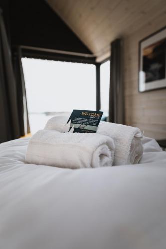 a book sitting on top of a bed with towels at Hattvika Lodge in Ballstad