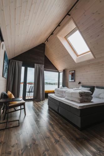a large bedroom with a large bed and windows at Hattvika Lodge in Ballstad