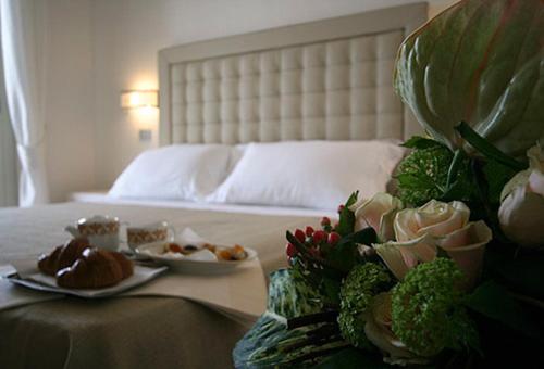 a bedroom with a bed with two plates of food at Hotel Alta La Vista in Marina di Castagneto Carducci