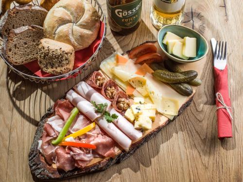 a table with a plate of food with bread and vegetables at Berg'k'hof Kaisertal - Alpine Hideaway in Ebbs