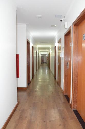 an empty hallway in an office building with wooden floors at Hotel Metrópole in São Lourenço