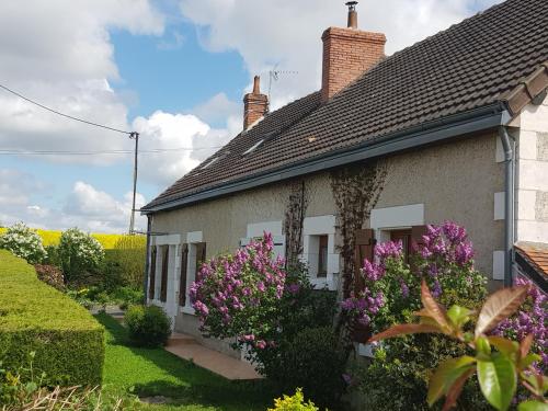 una casa con flores púrpuras delante de ella en Chambres D'hôtes Anne-Marie, en Châtillon-sur-Indre