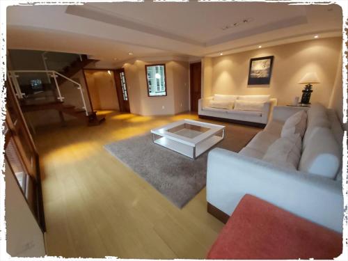 uma sala de estar com um sofá e uma mesa de centro em Residencial João Pessoa em Canela
