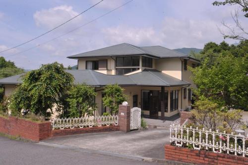 a house with a white fence in front of it at Tomomi Sanso / Vacation STAY 3832 in Yufu