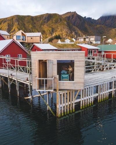 a tiny house on a dock in the water at Hattvika Lodge in Ballstad